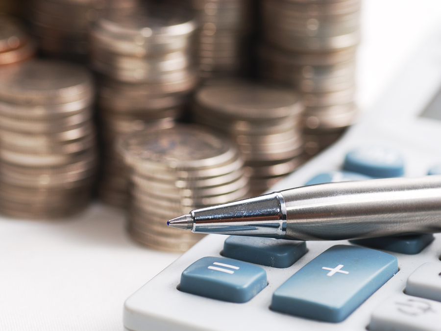 silver ball pen on calculator with stack coins background